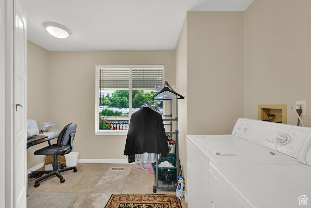 Laundry area featuring washer and clothes dryer, a desk, and light tile patterned floors