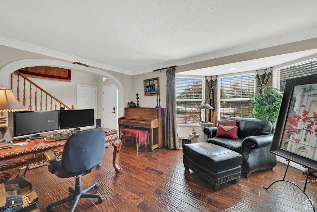 Office area with arched walkways, crown molding, and hardwood / wood-style floors