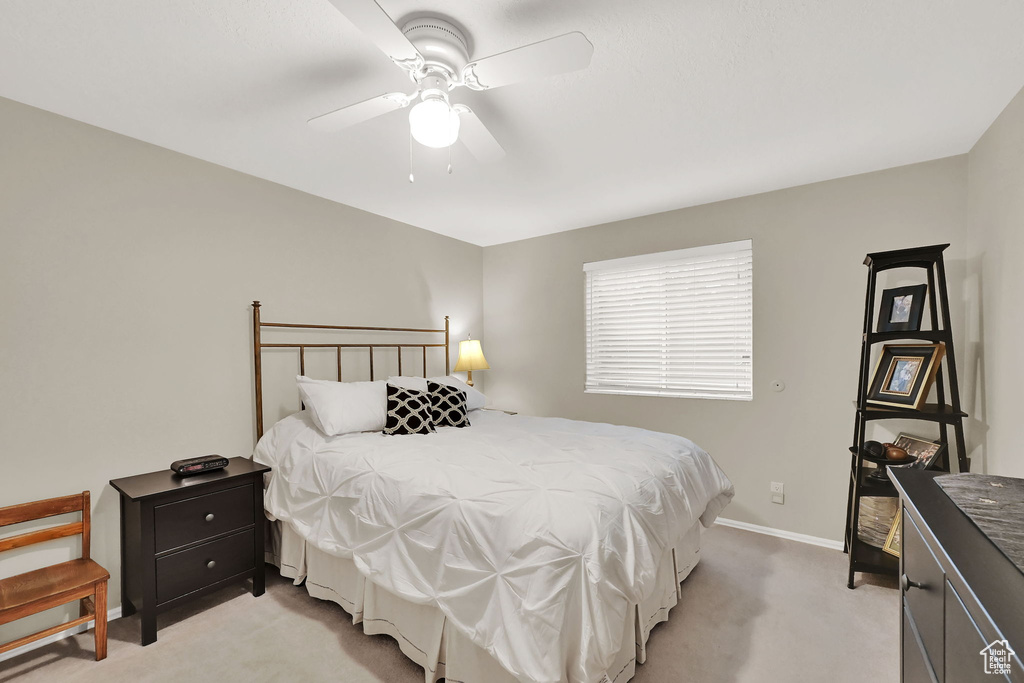 Bedroom with light carpet and a ceiling fan