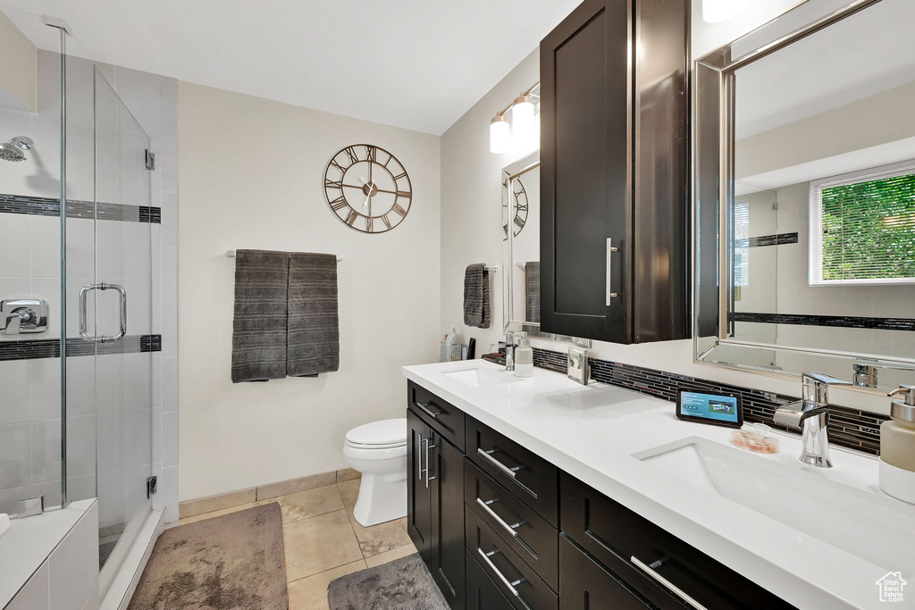 Bathroom featuring double vanity and a shower stall