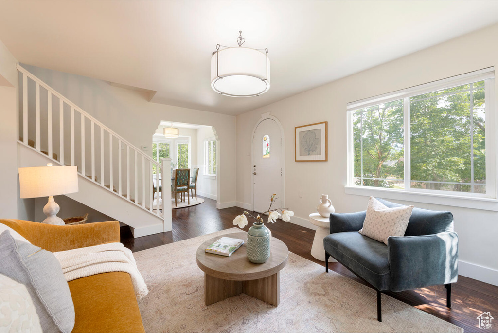 Living area featuring plenty of natural light, stairs, and wood finished floors