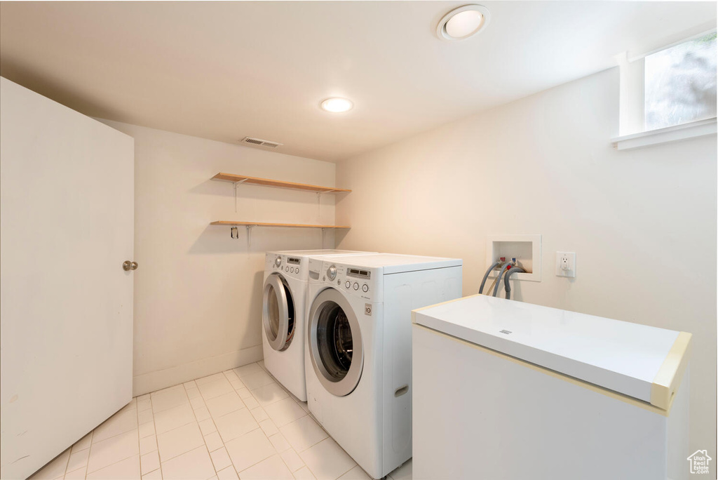 Laundry room with separate washer and dryer, recessed lighting, and light tile patterned floors