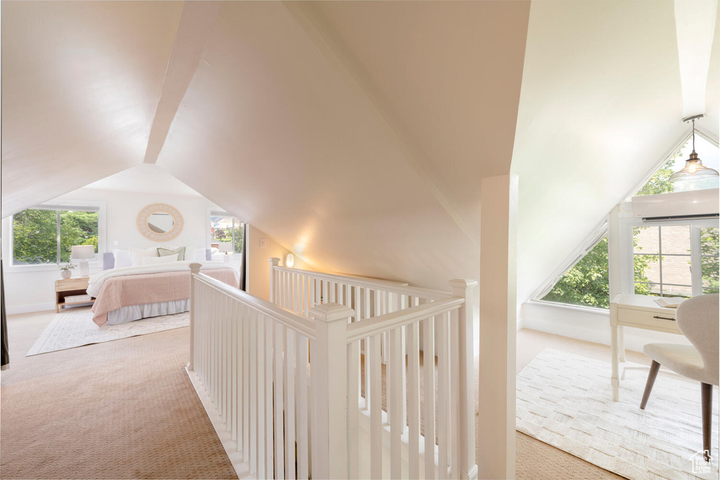 Corridor with carpet and lofted ceiling