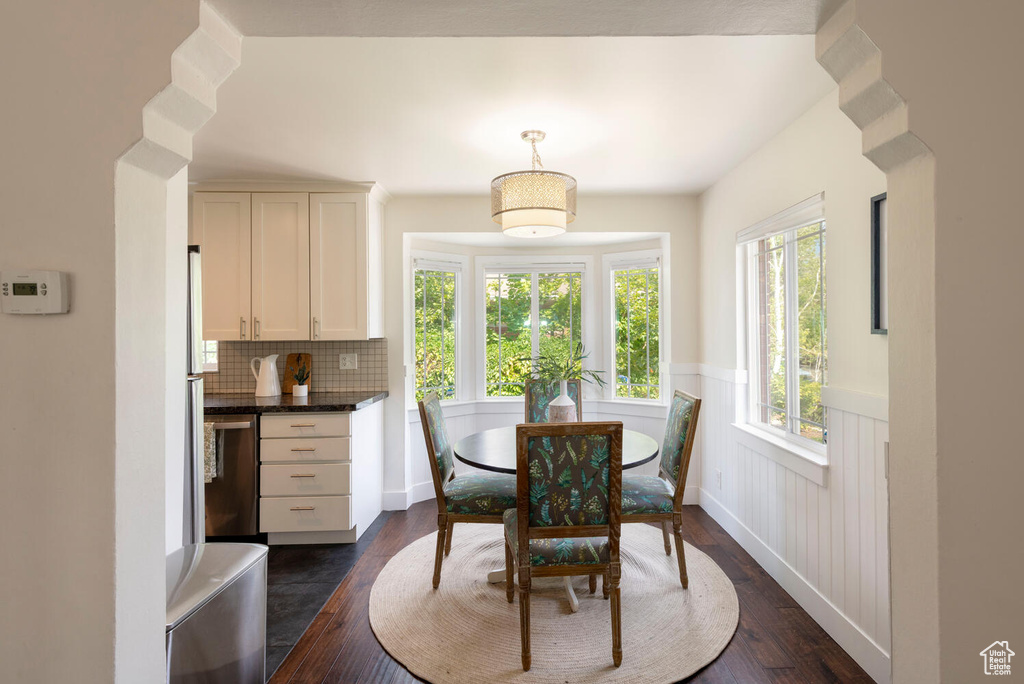 Dining room featuring wainscoting and dark wood-style flooring