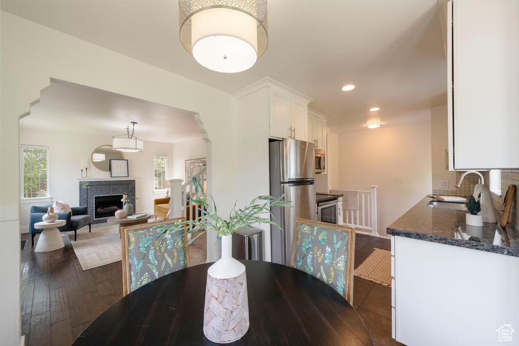 Dining room with recessed lighting, a fireplace, and dark wood finished floors