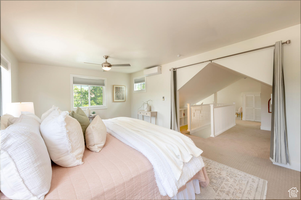 Bedroom featuring light carpet, a ceiling fan, and an AC wall unit