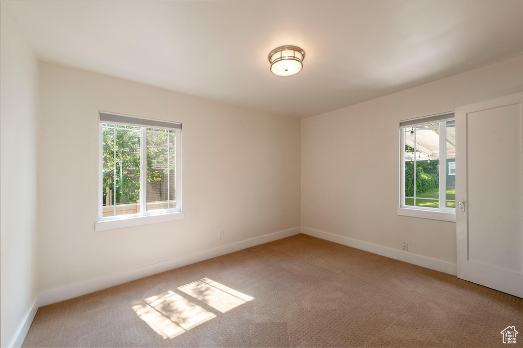 Empty room with plenty of natural light and light carpet