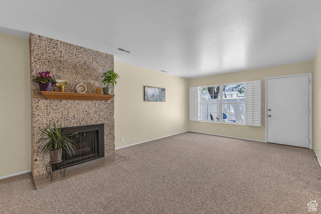 Unfurnished living room with carpet and a tile fireplace