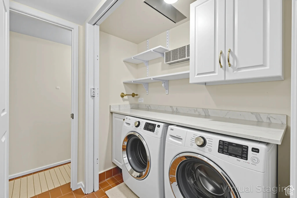 Laundry area with cabinet space, separate washer and dryer, and light tile patterned floors