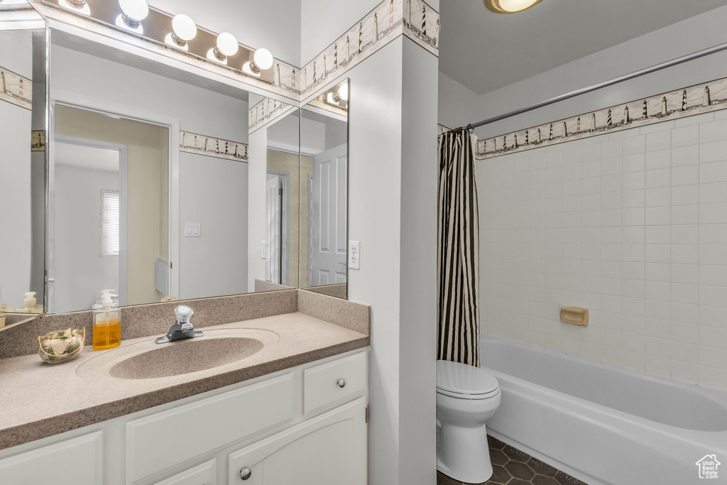 Bathroom featuring vanity, shower / bathtub combination with curtain, and tile patterned floors