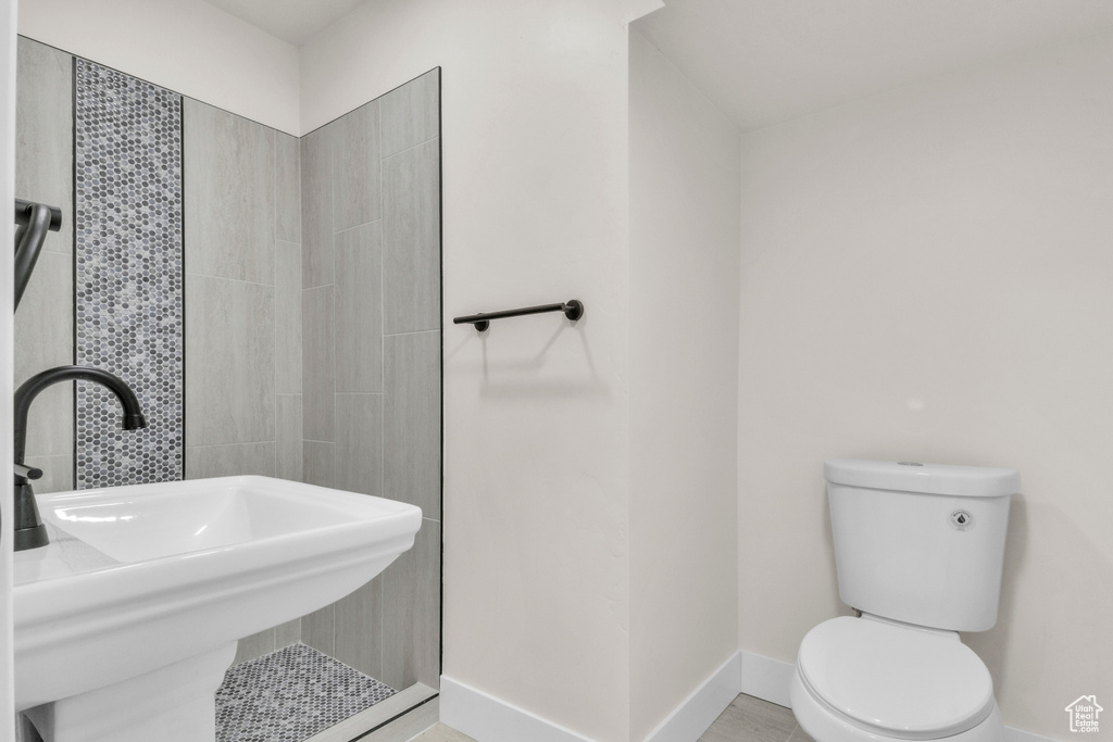 Bathroom featuring a sink and a tile shower