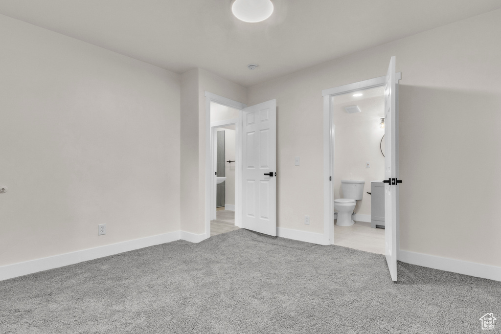 Unfurnished bedroom featuring carpet flooring and ensuite bath