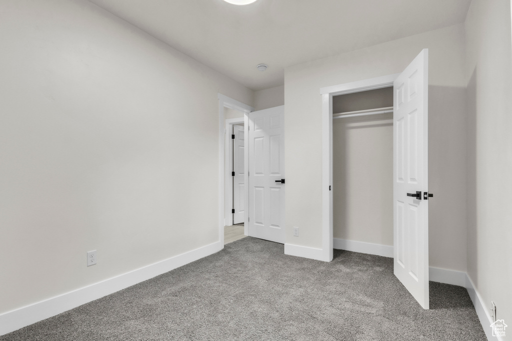 Unfurnished bedroom with carpet and a closet