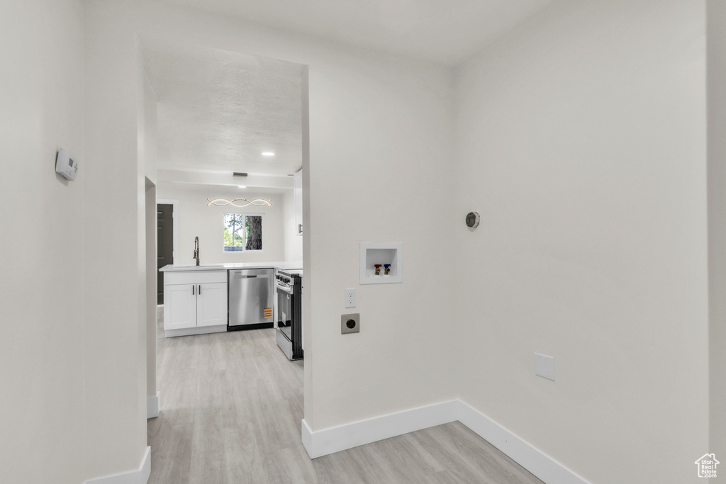 Laundry room with electric dryer hookup, washer hookup, and light wood-style floors