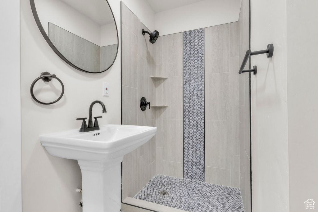 Full bathroom with a tile shower and a sink