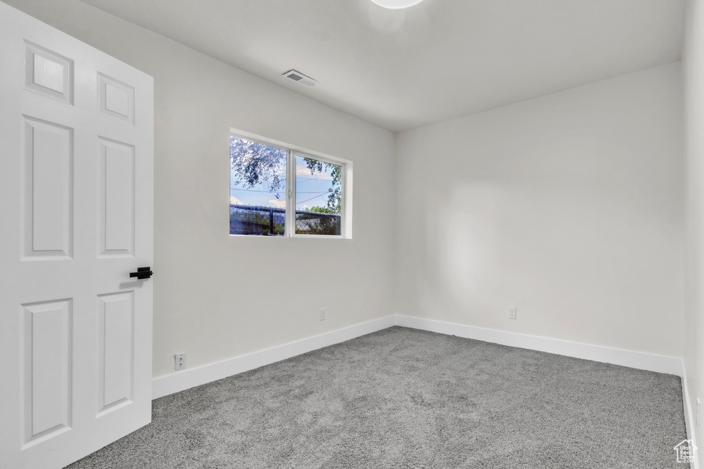 Carpeted empty room featuring baseboards