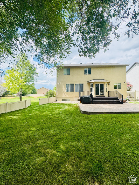 Rear view of house featuring stucco siding and a wooden deck