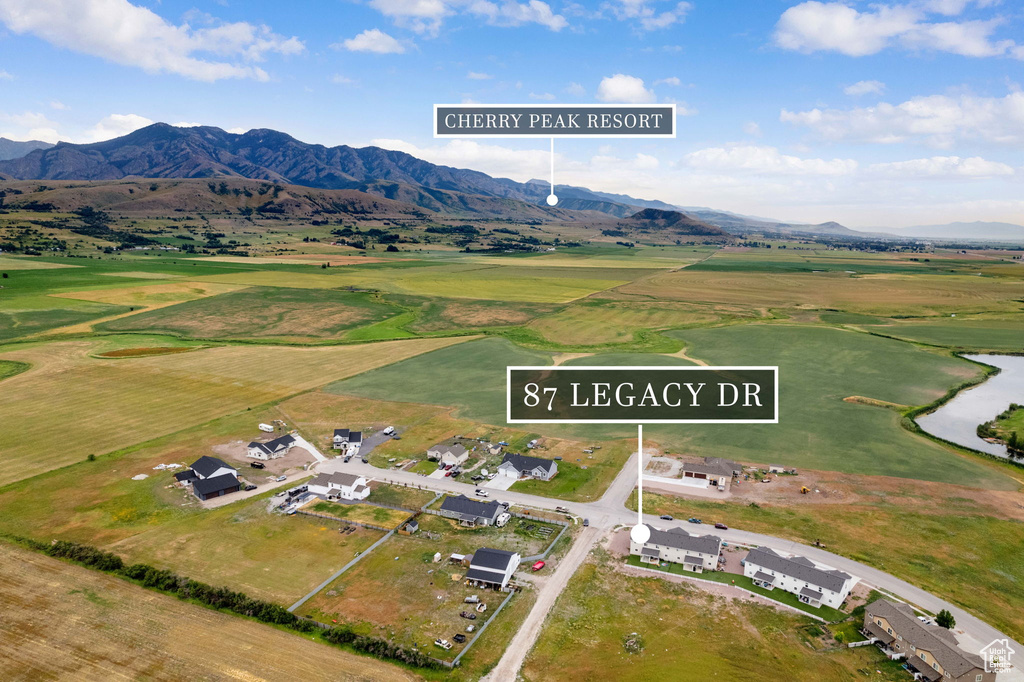 Aerial view of property and surrounding area with a mountainous background and a golf course