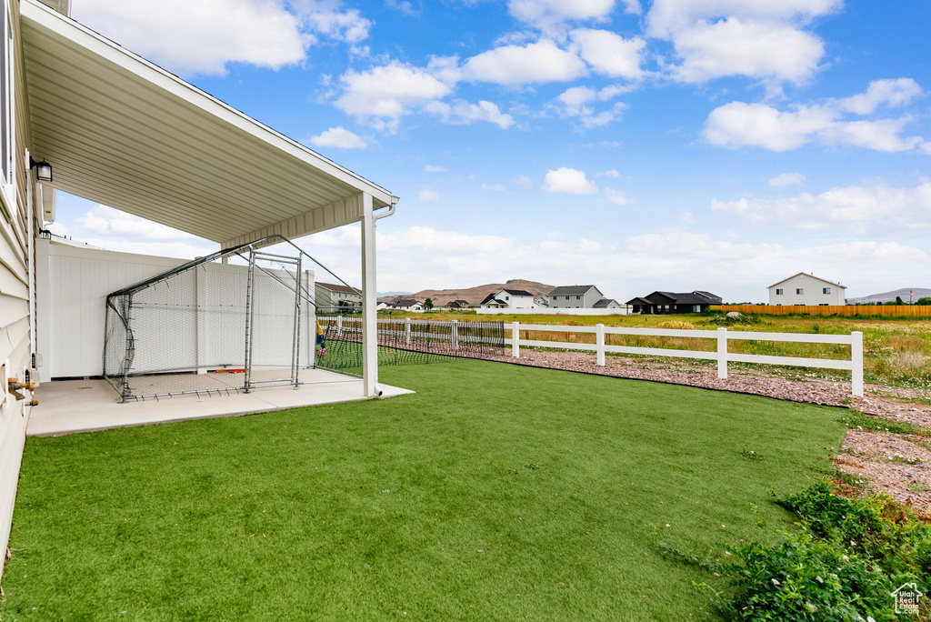 Fenced backyard featuring a patio area and a residential view