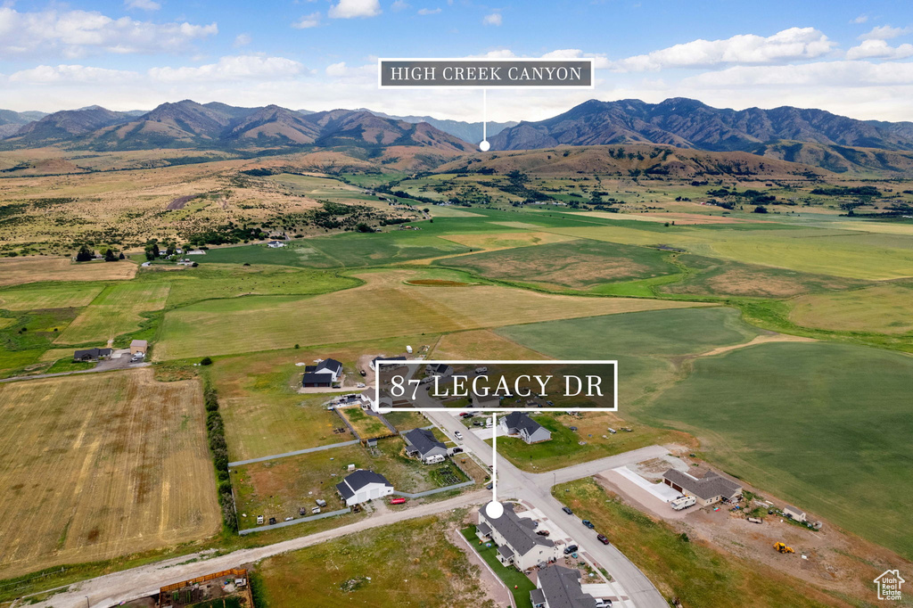 Aerial view of property and surrounding area with a mountain backdrop and property parcel outlined