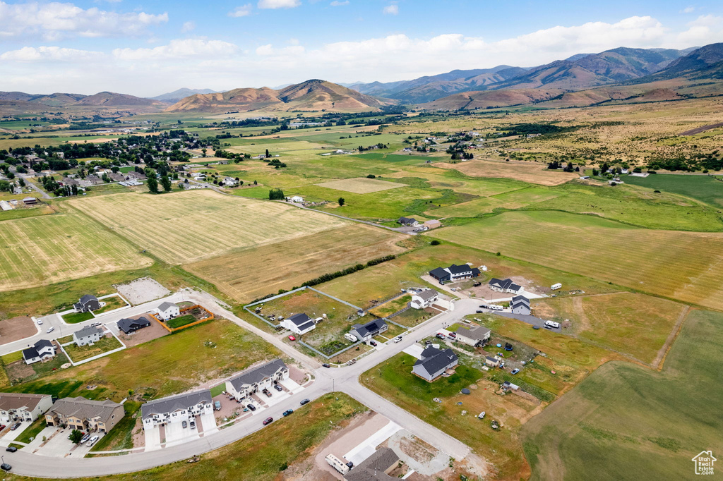 Aerial view of property and surrounding area featuring a mountainous background and rural landscape