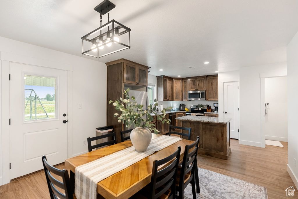 Dining room featuring healthy amount of natural light, light wood-style floors, and recessed lighting
