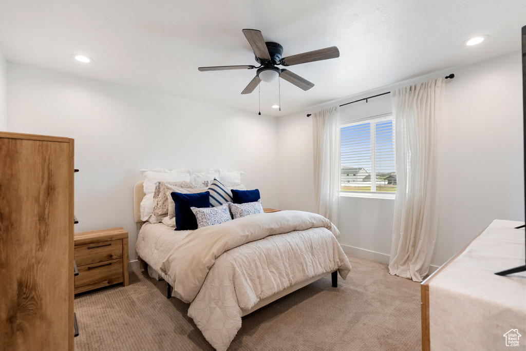 Bedroom with light colored carpet, recessed lighting, and a ceiling fan