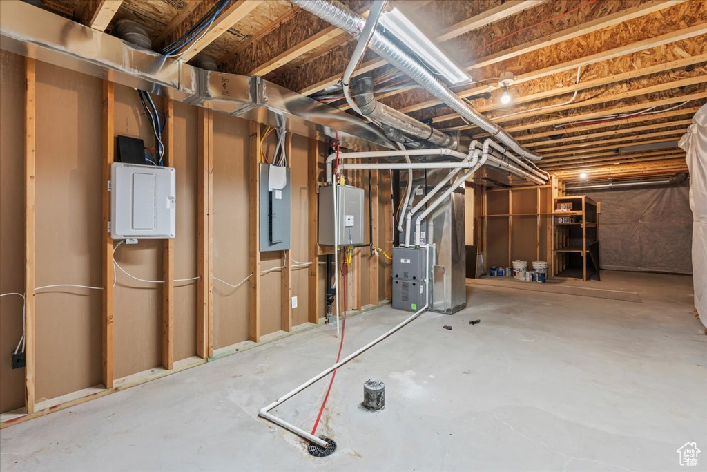 Unfinished basement with electric panel and heating unit