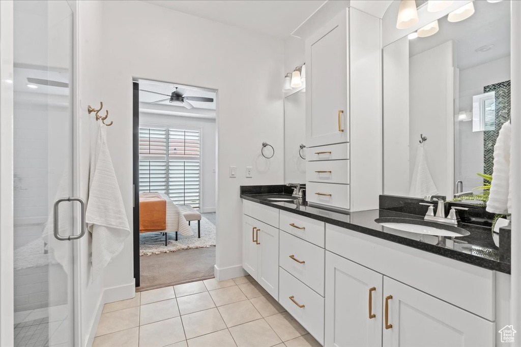 Bathroom with double vanity, tile patterned flooring, ceiling fan, a stall shower, and ensuite bathroom