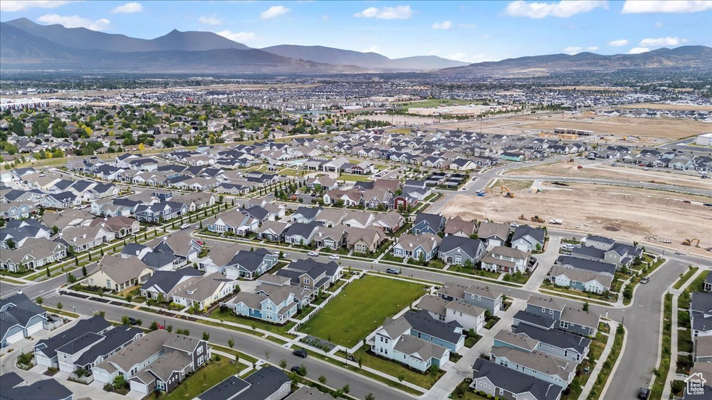 Aerial overview of property's location featuring a mountainous background and nearby suburban area