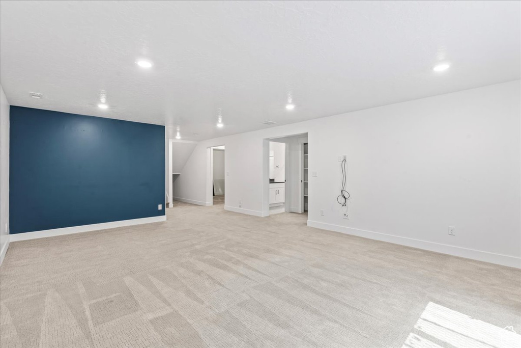 Unfurnished room with light colored carpet and recessed lighting