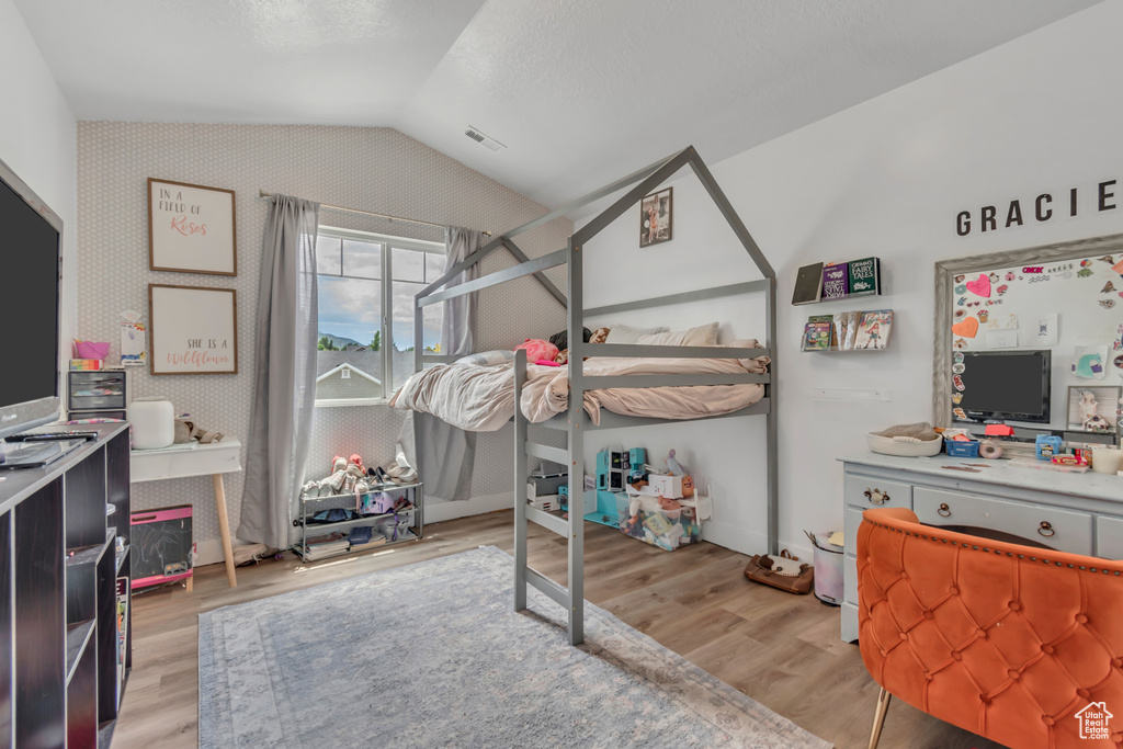 Bedroom featuring vaulted ceiling and light wood-type flooring
