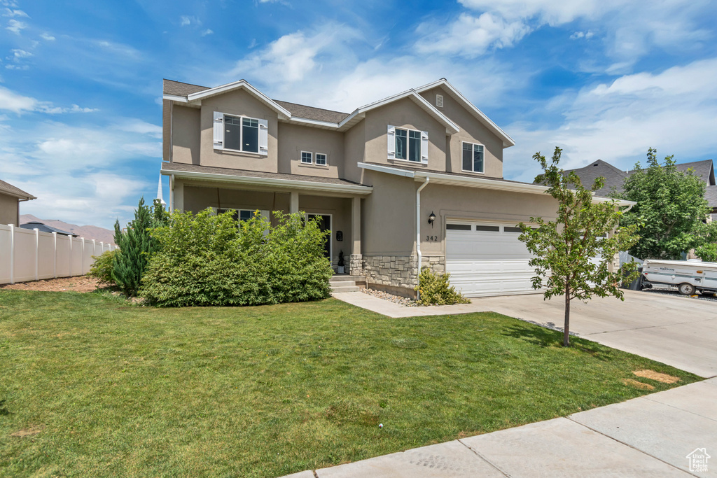 Traditional home featuring stone siding, stucco siding, driveway, and a garage