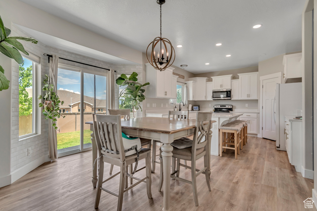 Dining area featuring light wood-style flooring, a chandelier, and recessed lighting