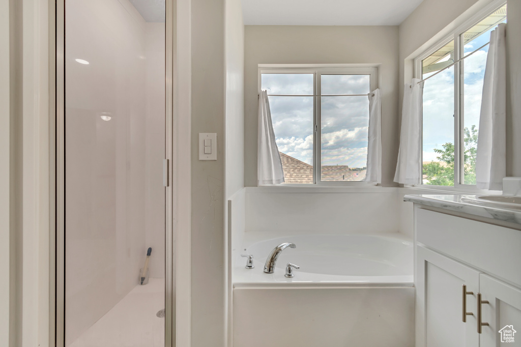 Full bathroom with a stall shower, a bath, and vanity