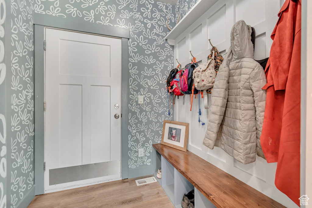 Mudroom with wallpapered walls and wood finished floors