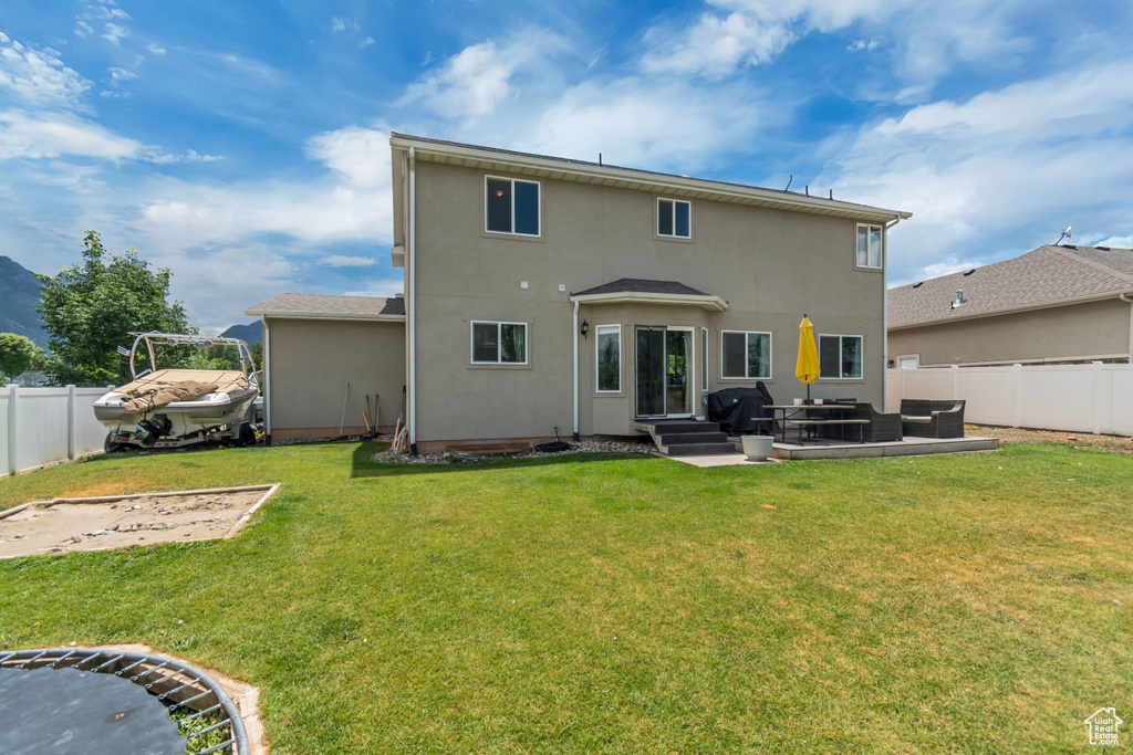 Back of property featuring an outdoor living space, a fenced backyard, stucco siding, and a patio