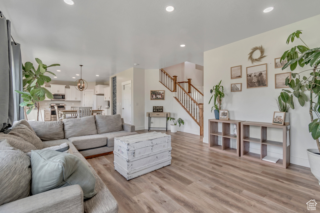 Living room with stairs, light wood-style flooring, and recessed lighting