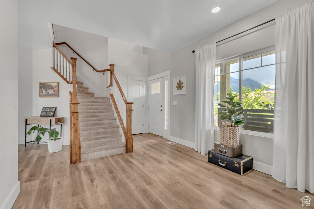 Foyer entrance featuring wood finished floors and stairway