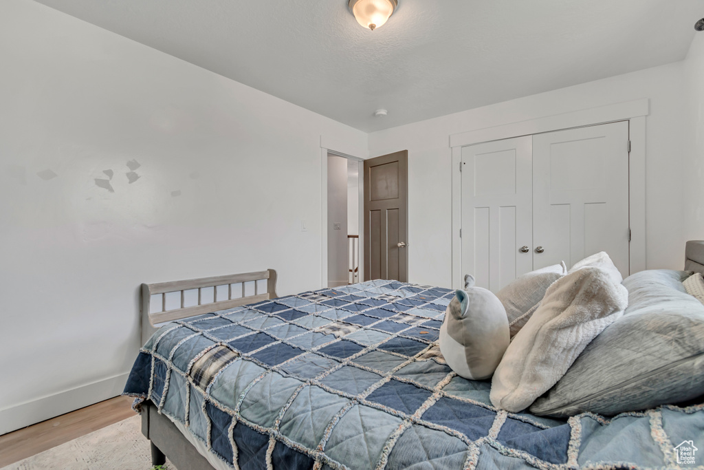 Bedroom with wood finished floors and a closet