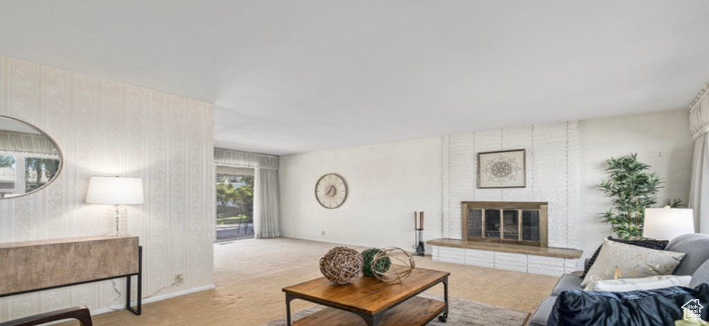 Carpeted living area with a brick fireplace