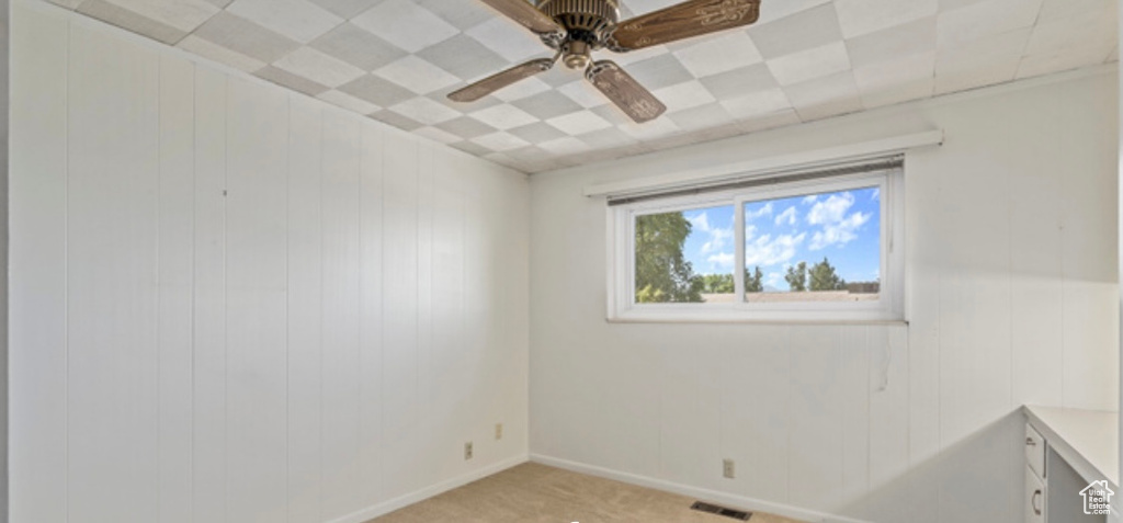 Unfurnished room featuring ceiling fan and light carpet