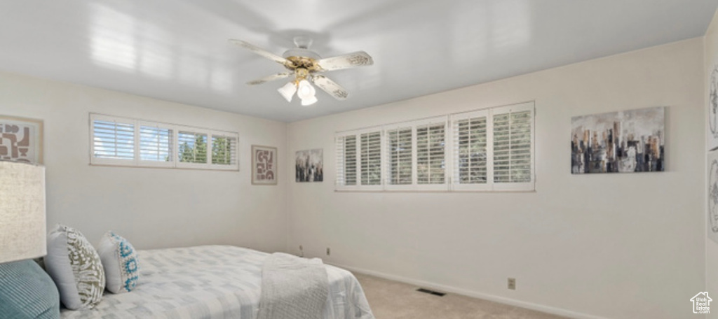 Carpeted bedroom with baseboards and ceiling fan