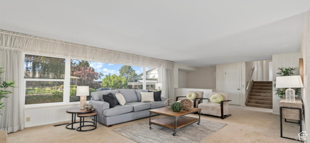 Living room featuring light colored carpet and stairway