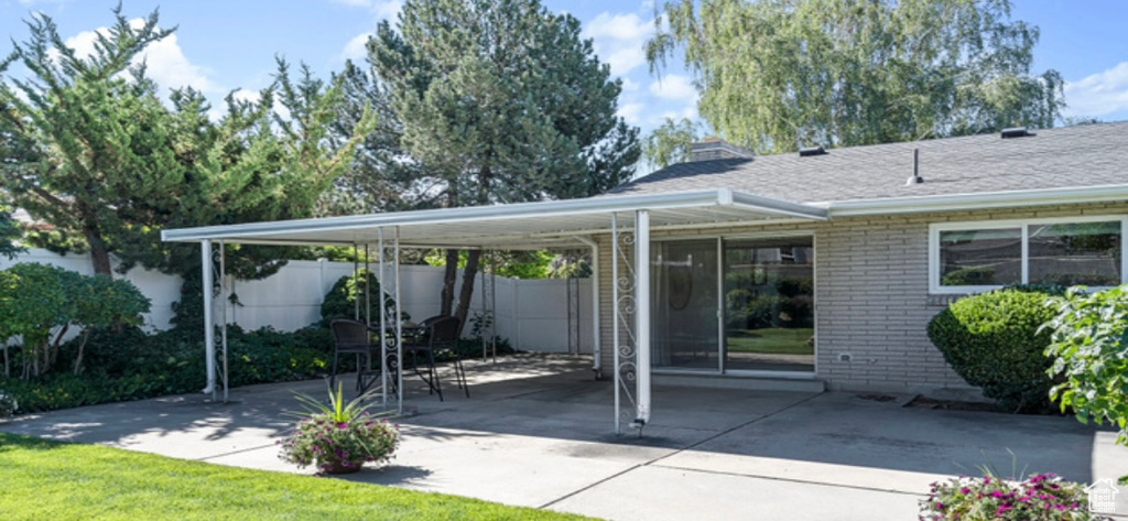 View of patio with concrete driveway and an attached carport