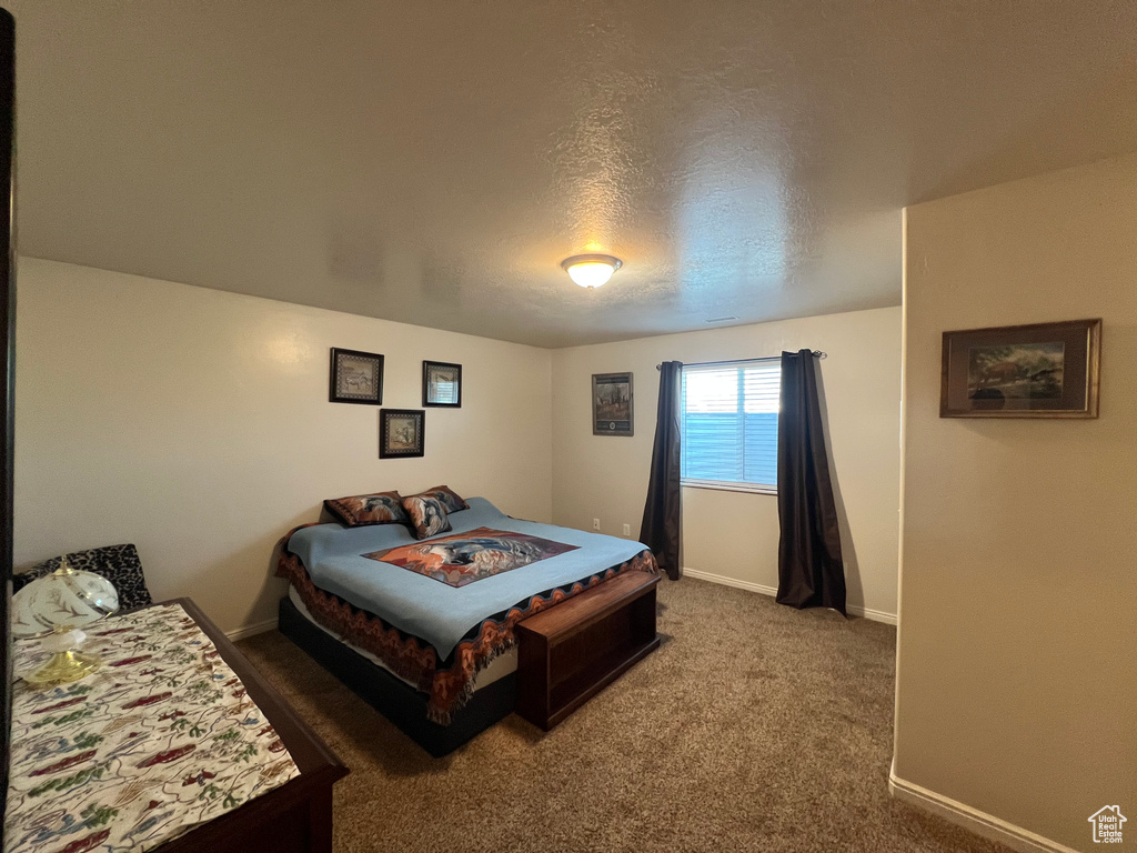 Carpeted bedroom with baseboards and a textured ceiling