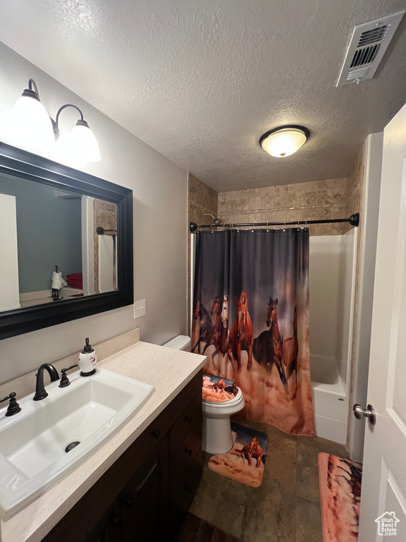 Full bath featuring vanity, shower / tub combo, and a textured ceiling