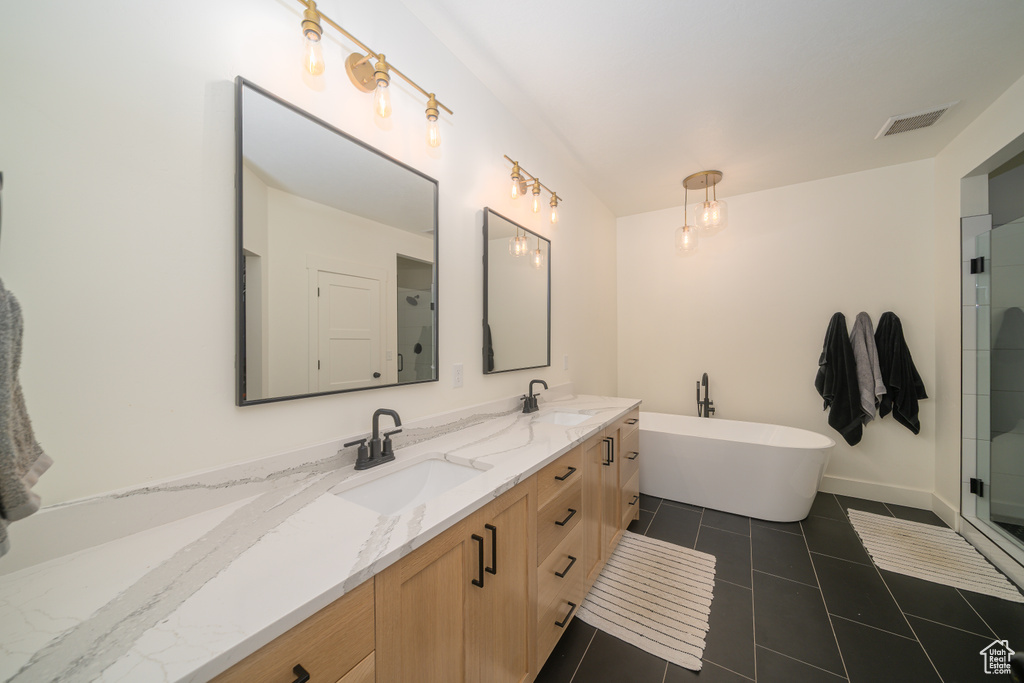 Full bathroom with double vanity, a soaking tub, tile patterned flooring, and a shower with door