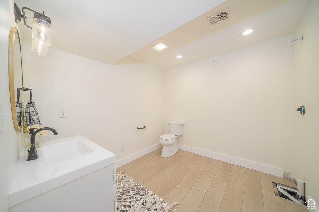 Bathroom featuring vanity, wood finished floors, and recessed lighting