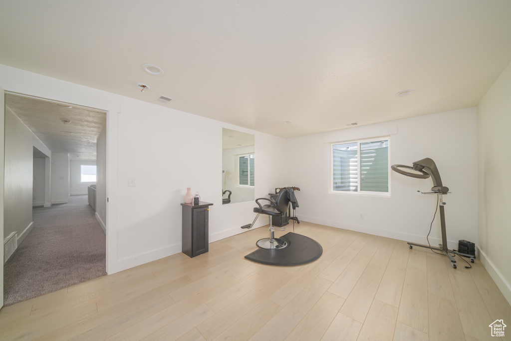 Exercise area featuring light wood-style flooring and baseboards